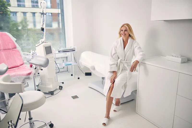 Smiling woman in a robe in a modern medical spa treatment room
