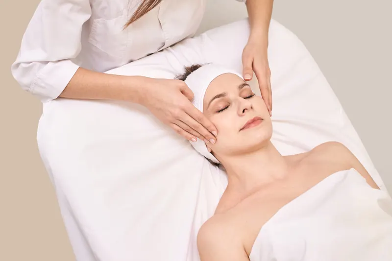 Woman relaxing during a facial massage at a med spa